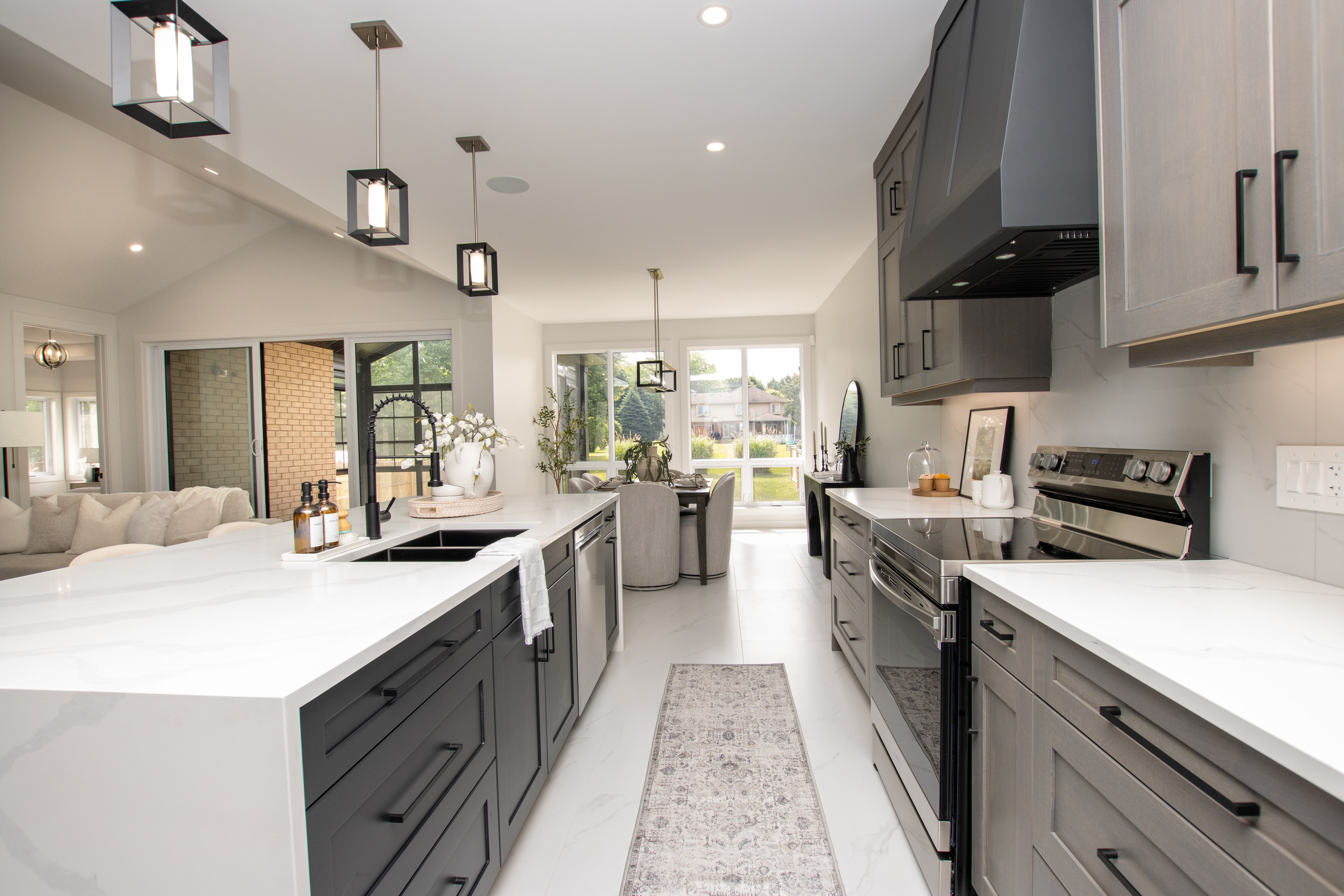 Grey galley kitchen with quartz countertops and open to dining